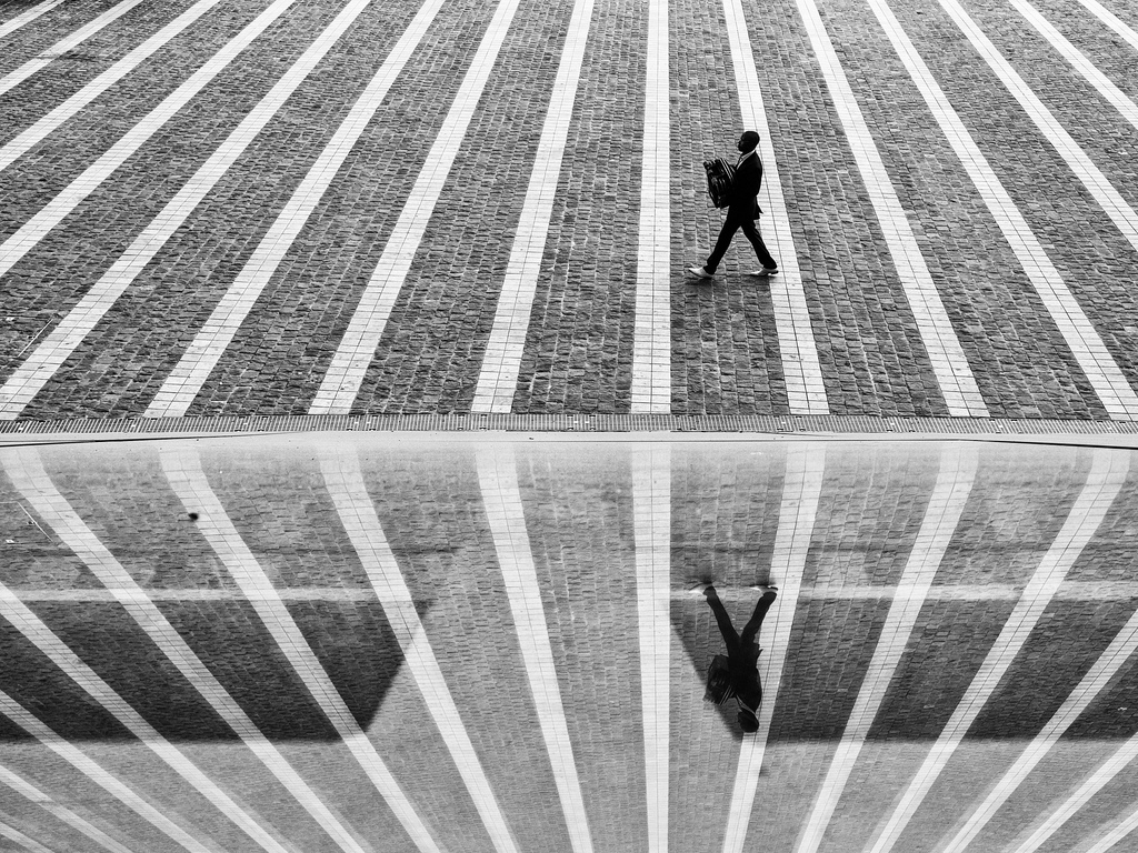 Picture of man walking between lines on a road