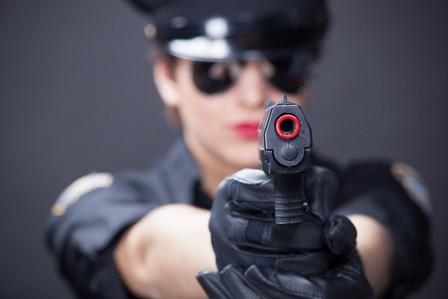 a photo of a police woman who is pointing a gun