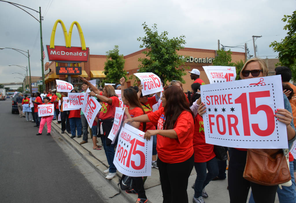 Protesters holding signs outside of a McDonald's