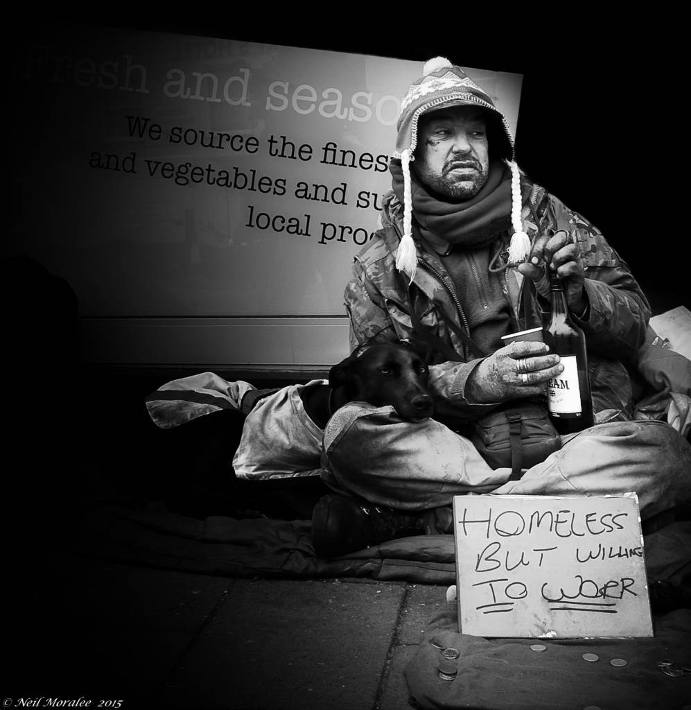 Homeless man with a sign stating "homeless, but willing to work"