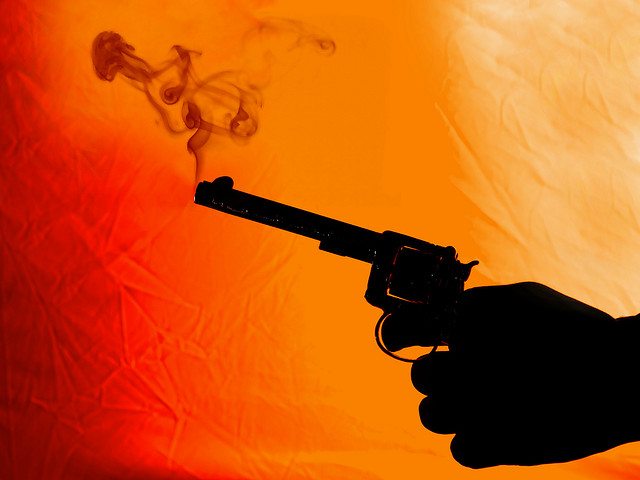 Image of a smoking gun against a red/orange background.