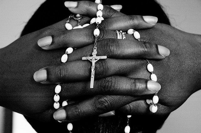 Image of hands holding rosary beads.