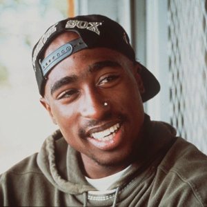A picture of Tupac Shakur smiling.