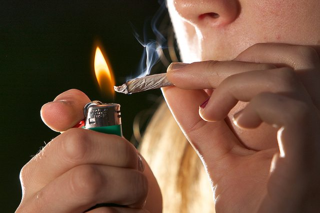 Image of woman smoking a joint.