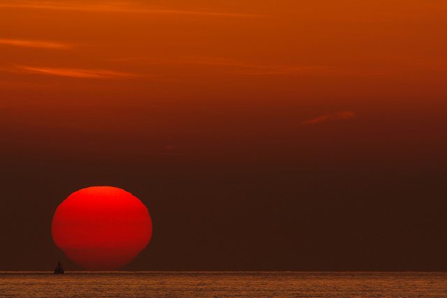 Image of the sun setting on the sea.