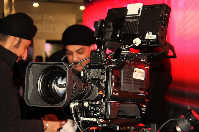 Image of a camera crew and a video camera.