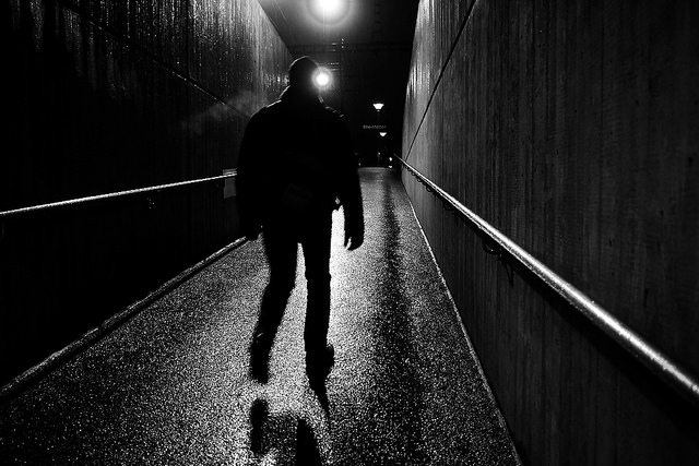 Image of a figure walking down a dark alley.