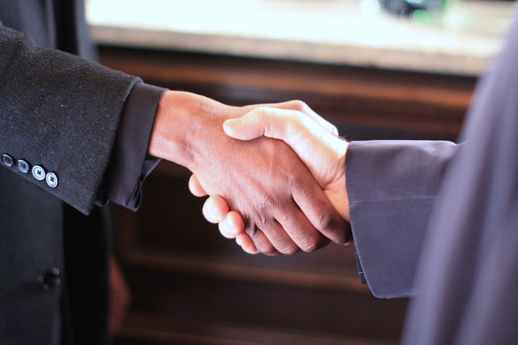 A photo of two people shaking hands.
