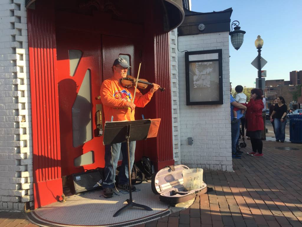 Busking violinist Bill Hassay plays the violin on the corner of M Street and Wisconsin Avenue