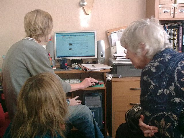 Elderly gathered around a computer
