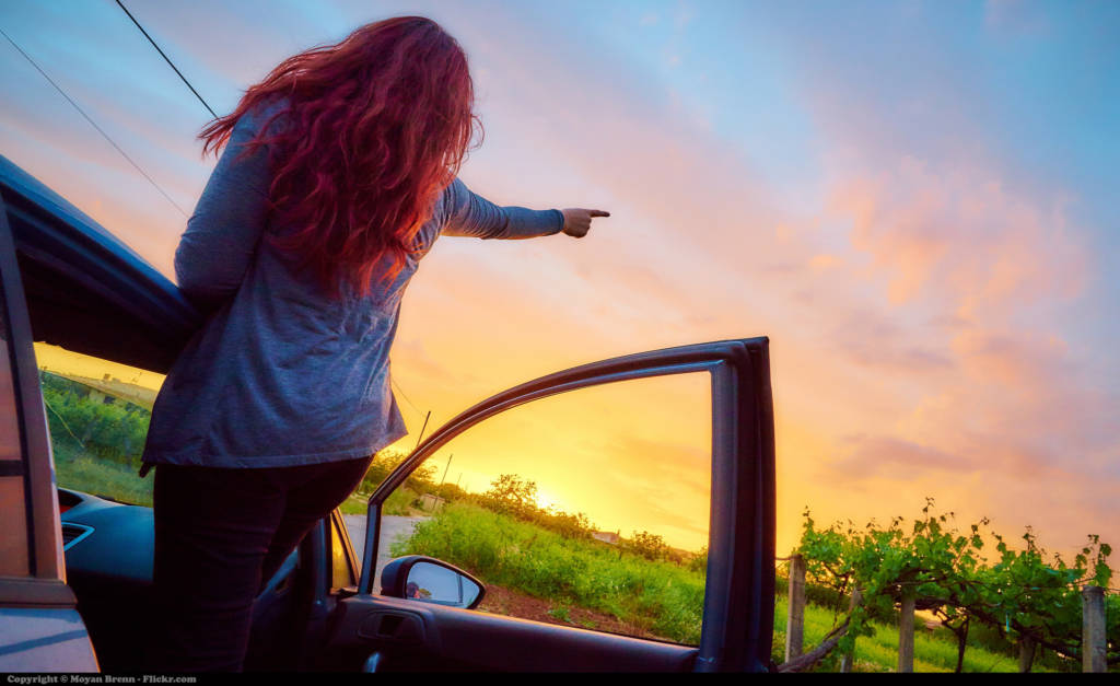 A woman points off into the sunset.