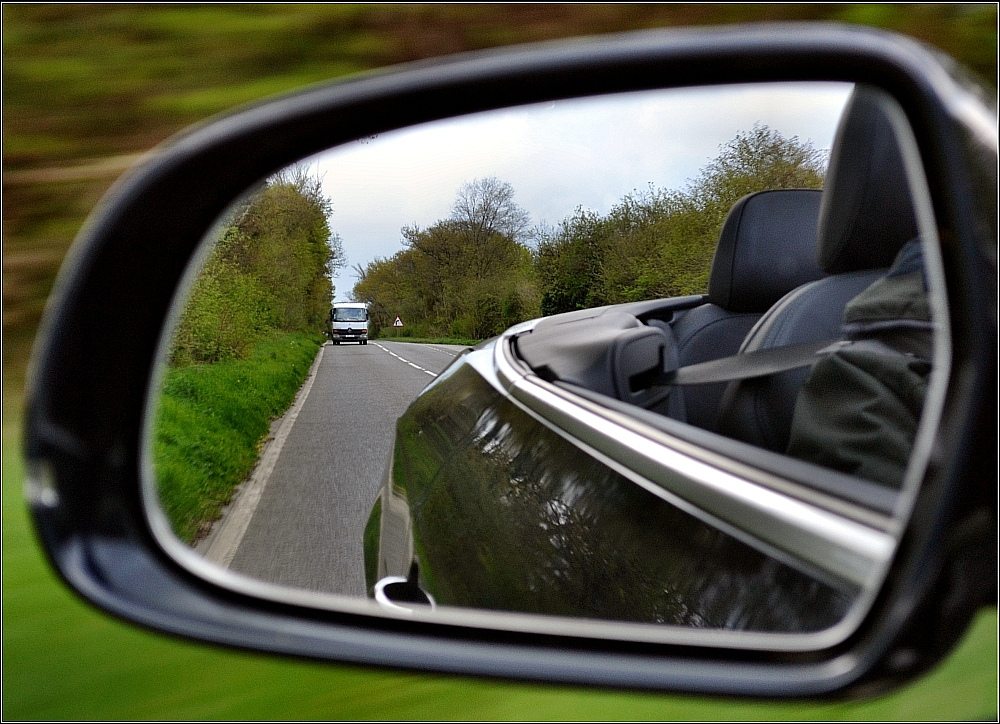 A view out the front side mirror of a car.