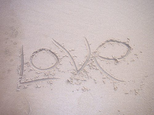 The word love drawn in sand.