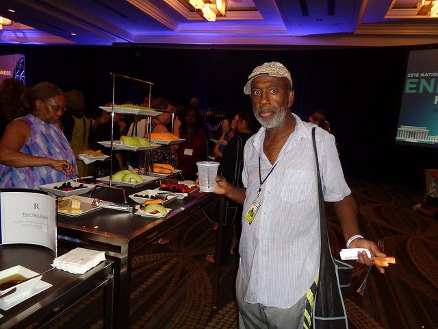 Kanell Washington standing with a place of food and looking at the camera