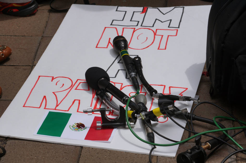 A sign lays on the grounds with the words "I'm not a racist". A microphone has fallen on top of it, partially obscuring the words.