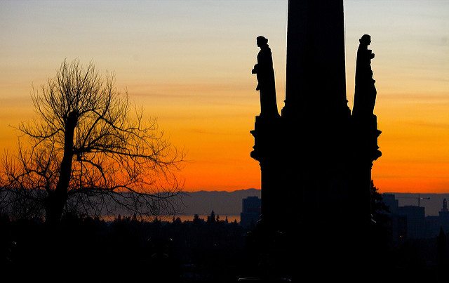 Guardian angel statutes silhouetted in the sunset