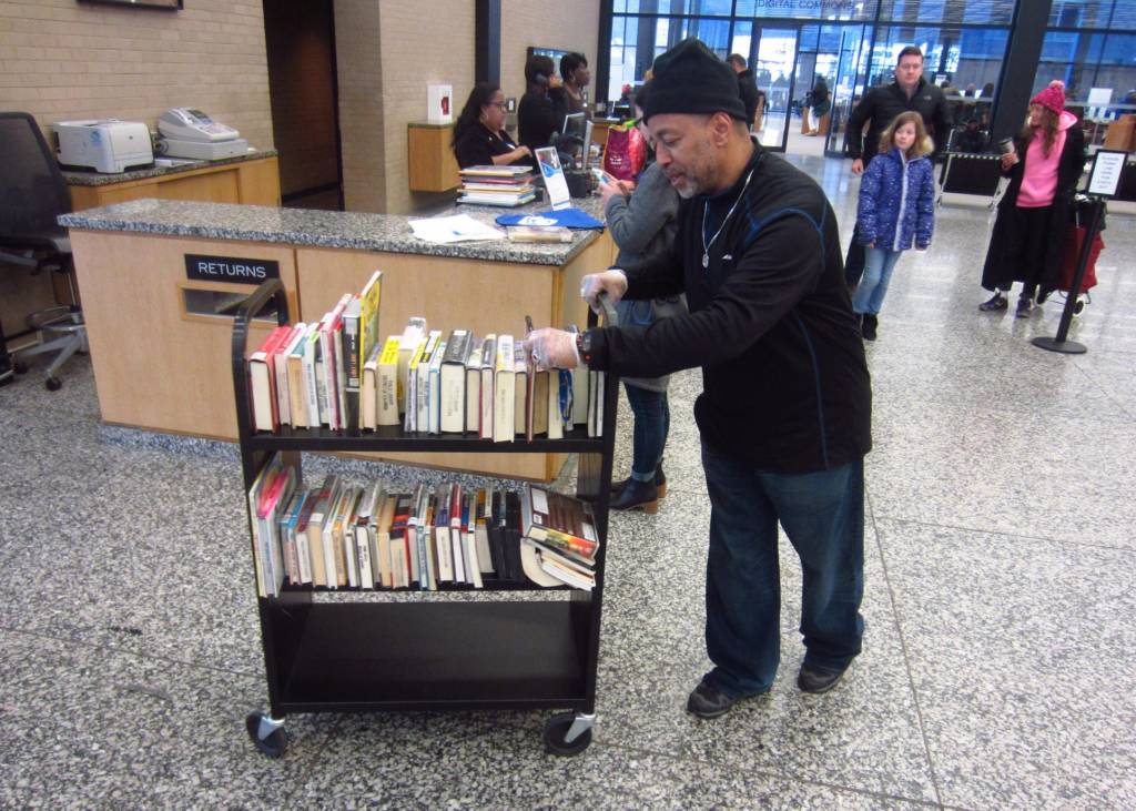 Glen Wells, MLK Library information specialist, pushes a cart of books.