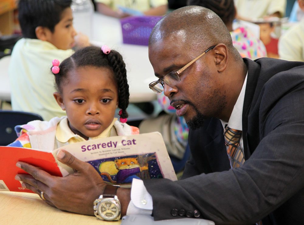 A photo of DCPS Chancellor Antwan Wilson reading to a Tubman Elementary student.