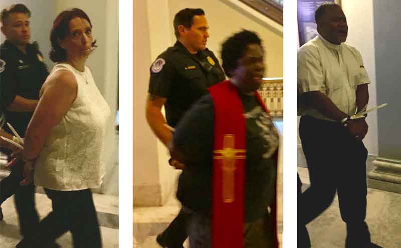 Three individuals, including a reverend, being led out of a Senate office building in zip-tie restraints.