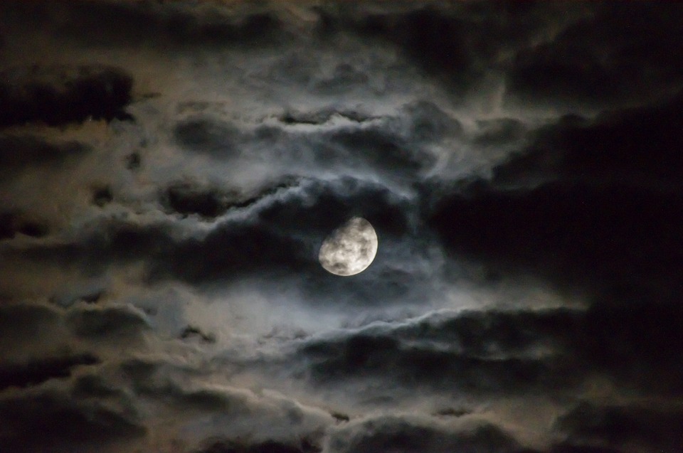 Photo of a full moon in the cloudy night sky
