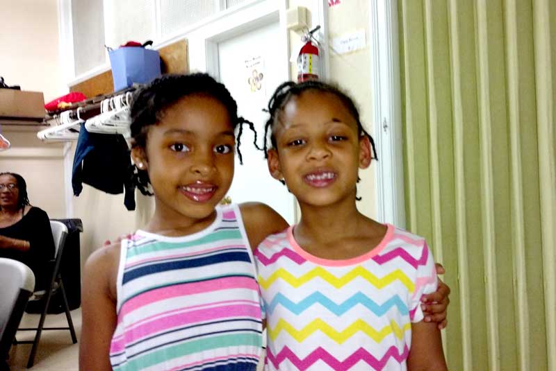 Two young girls with their arms around each other's shoulders at the Shaw Community Center.