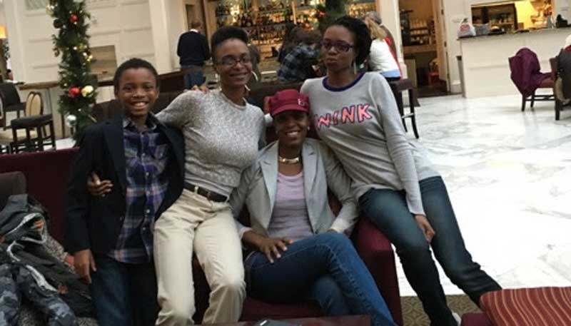 A photo of Ms. Lewis with her family near a public Christmas display.