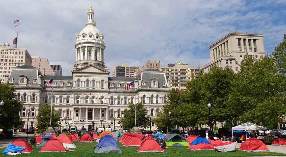 A field brightly colored tents in front of Baltimore's city hall.