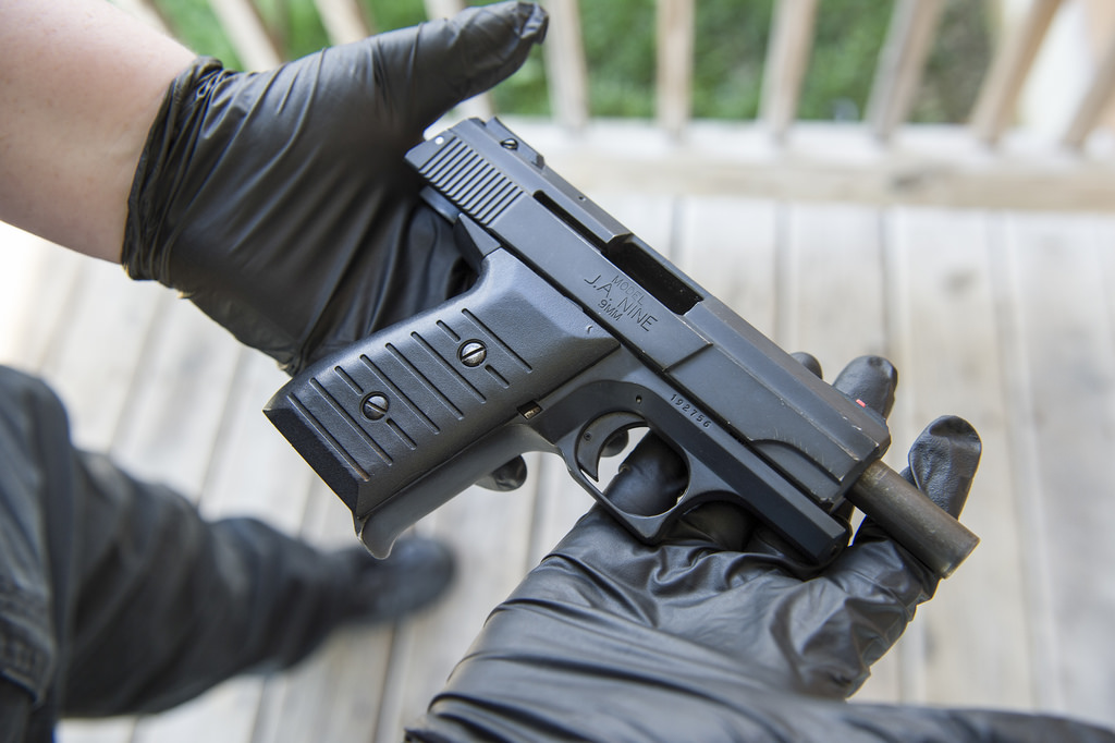 A picture of two gloved hands holding a gun