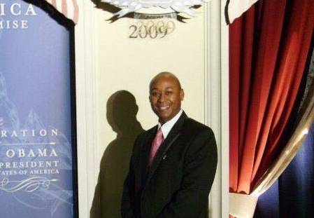 Photo of Michael wearing a suit and posing at a formal event.