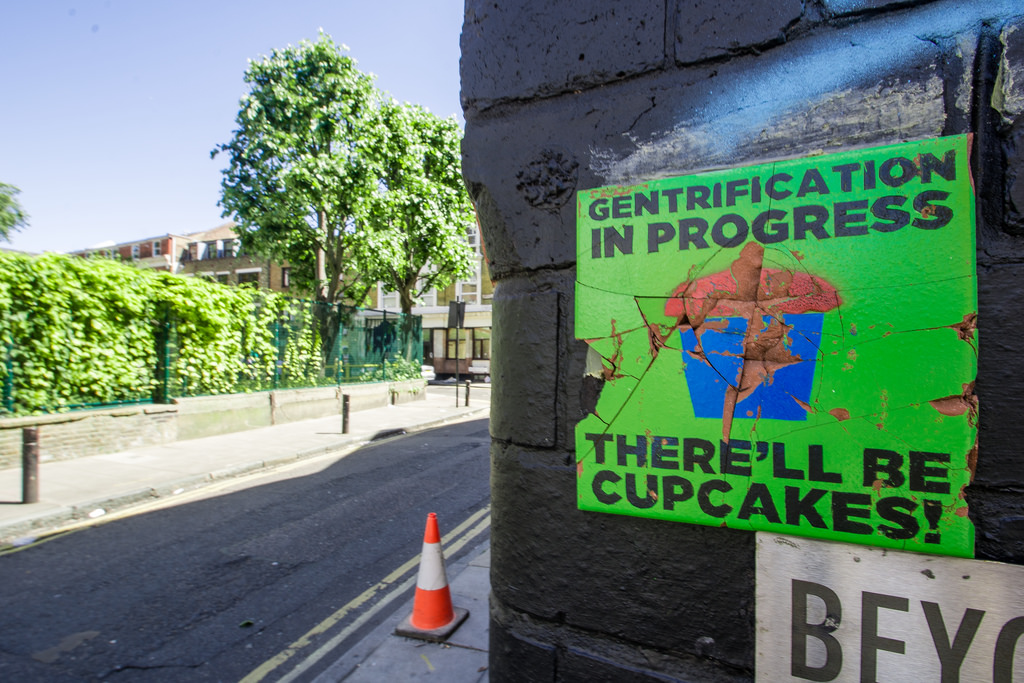 A sign that reads "gentrification in progress, there'll be cupcakes".