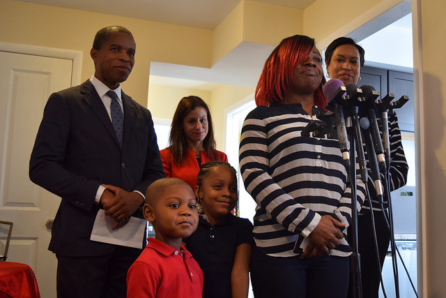 New tenants Tremaine Anderson and her two children, her landlord Don Gladstone, DHS Director Zeilinger and Mayor Muriel Bowser gather in the Andersons' new home.
