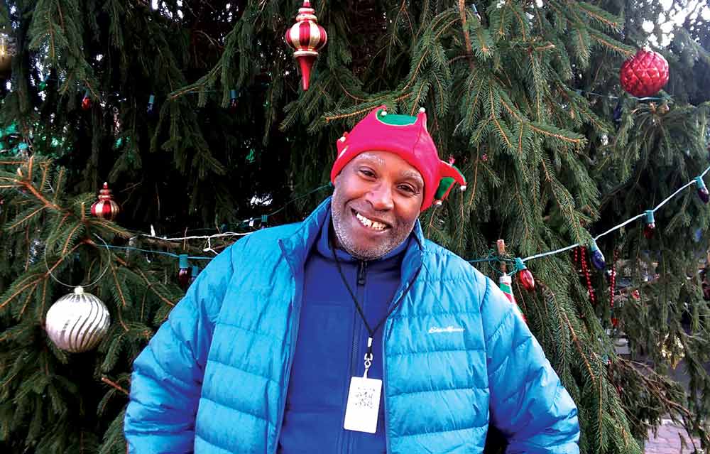 Wendell Williams stands in front of a Christmas tree.