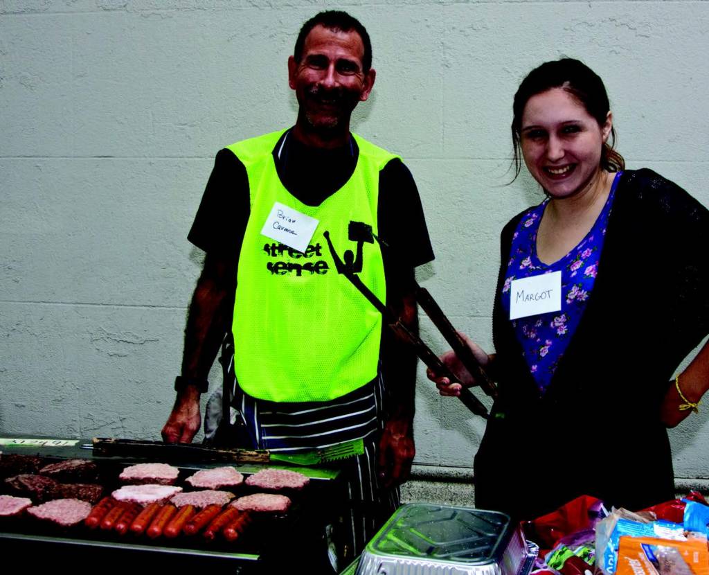 Street Sense Executive Director Brian Carome and a George Washington University student volunteer Margot Hoffman serve at the August 23rd vendor appreciation barbecue.