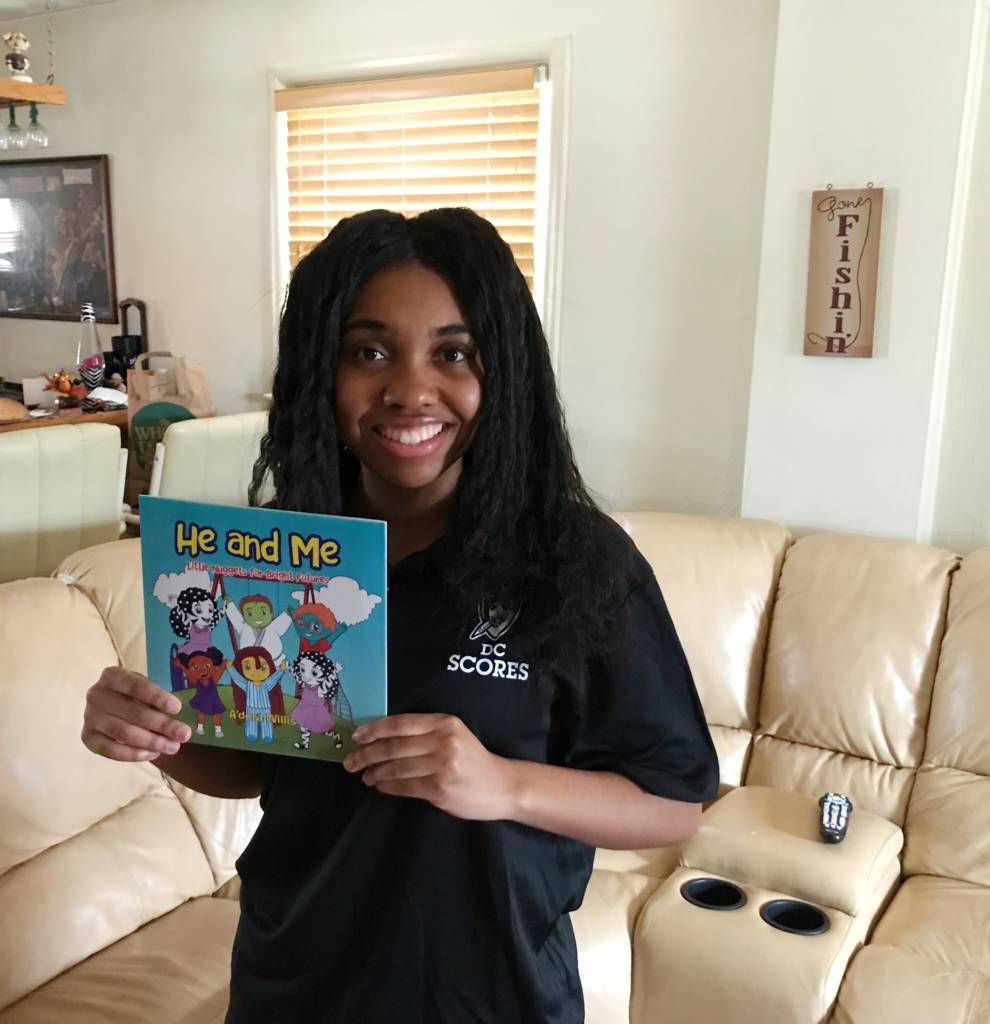 Photo of A'dora Willis holding her book, "He and Me"