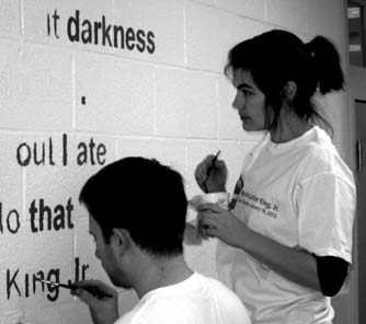 Volunteers through HandsOn Greater DC Cares paint inspirational quotes along the halls of Tyler Elementary.