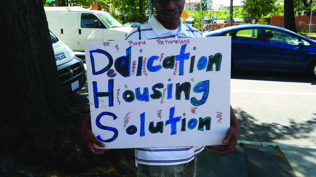 File photo of a sign held by a participant in a May 9 protest led by families in the rapid rehousing program and community advocates.