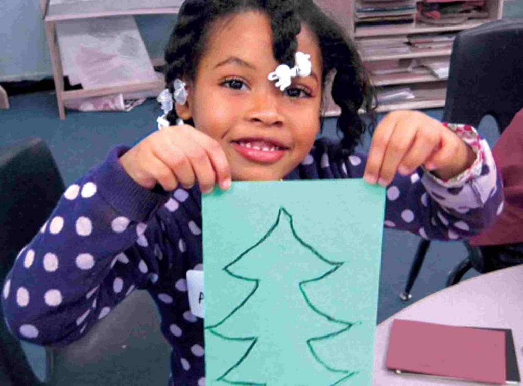 Photo of Ahmiya Barnes drawing a Christmas tree for her mother at D.C. General Hospital