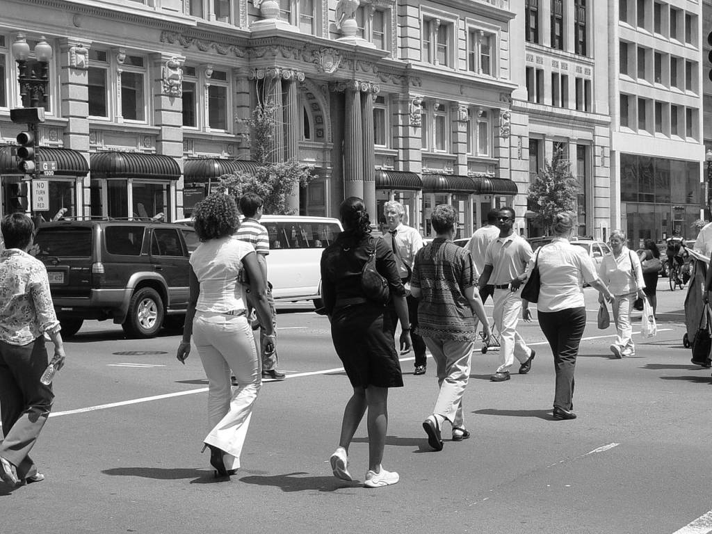 A black and white photograph of pedestrians crossing a D.C. street