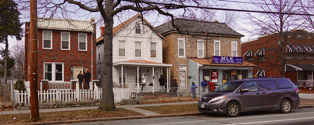 A photograph of houses and a parked car on a street in Anacostia, D.C.