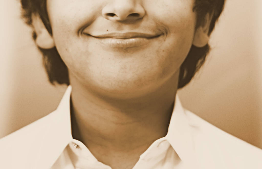 A photograph of a boy , from the nose down, smiling