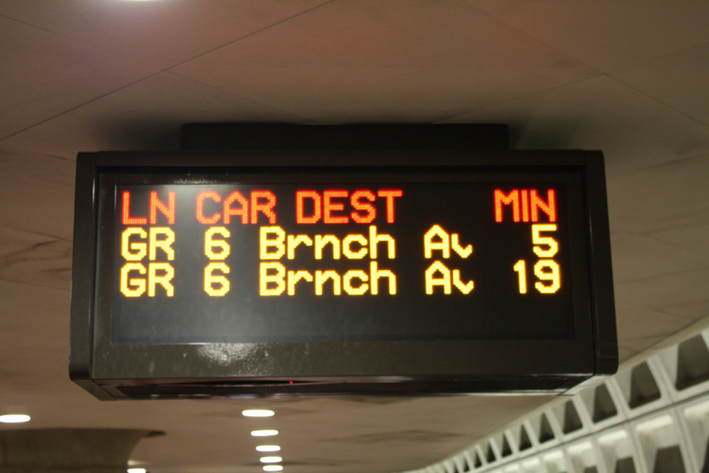 A photograph of a metro station sign announcing the next trains.