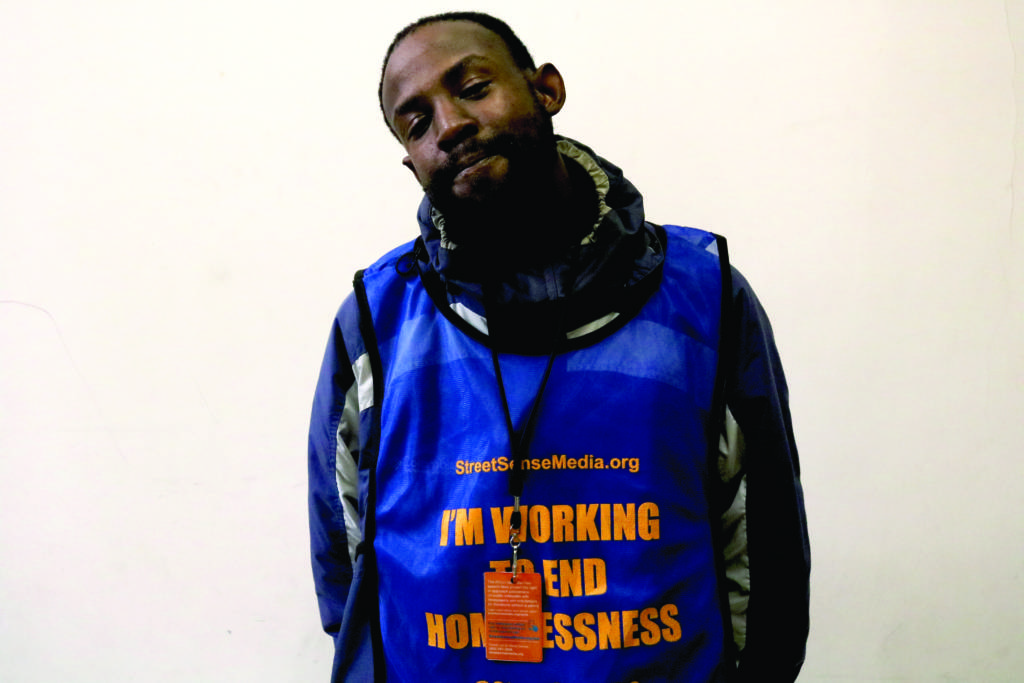 A photograph of Street Sense Media vendor Marcus McCal, wearing his Street Sense vendor's vest.