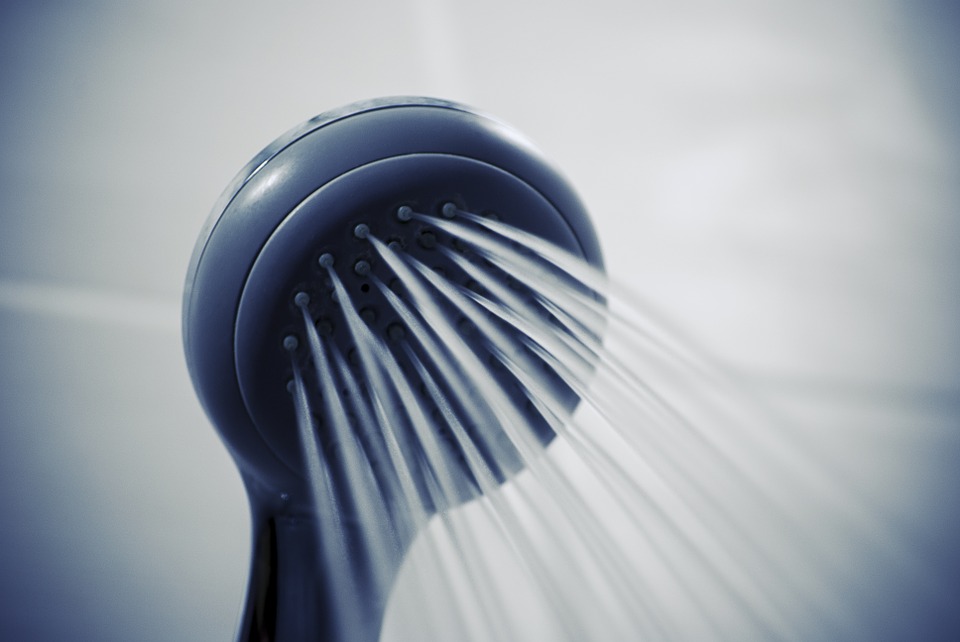 A photograph of a showerhead spraying water.