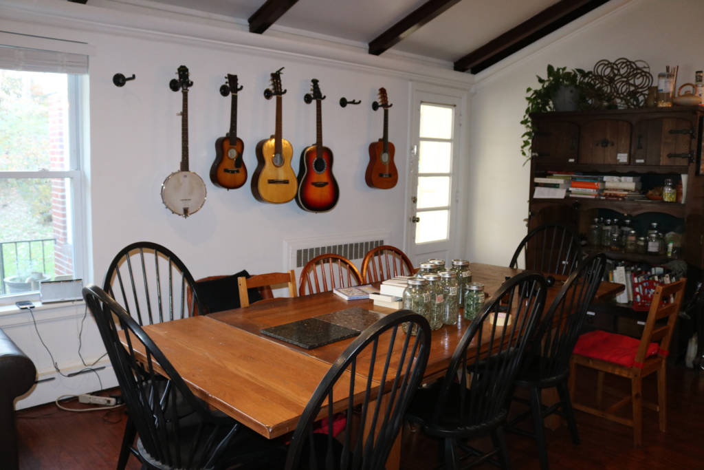 A photo of a dining room with jars of herbs and guitars hanging on the wall
