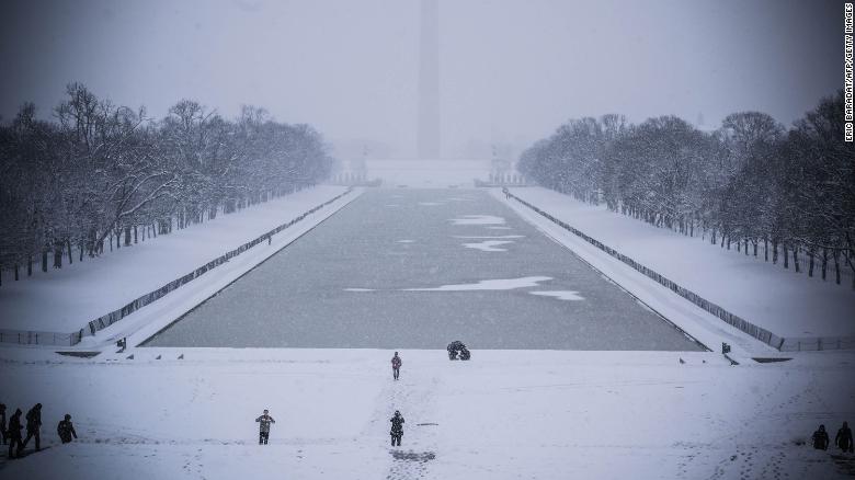 Photo of snow along the reflecting pool with the Washington Monument in the background.