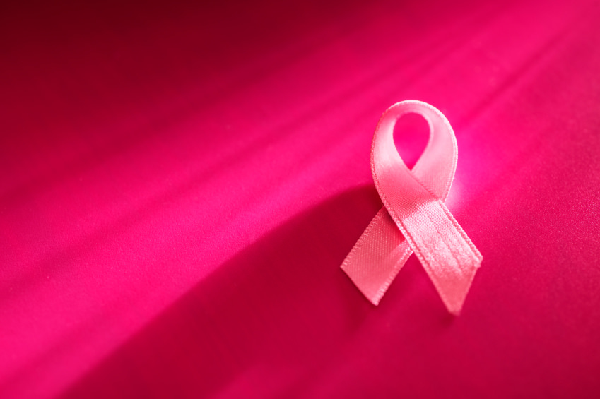 A photo of a pink ribbon in front of a dark pink background.