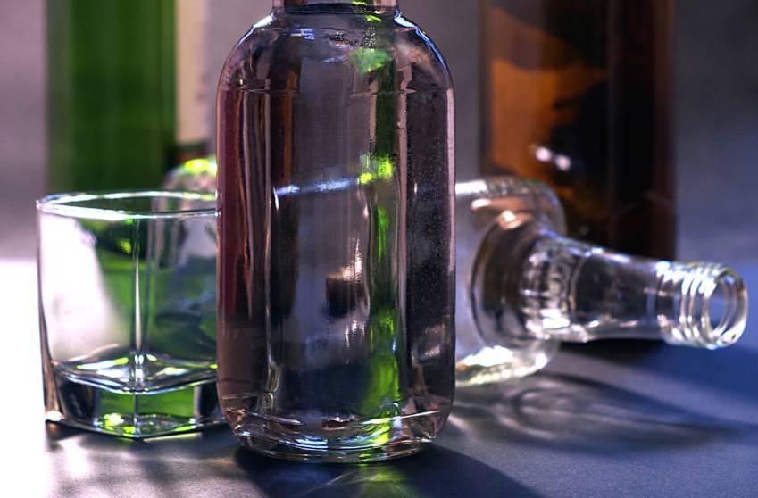 A photo of four class alcohol bottles and an empty glass