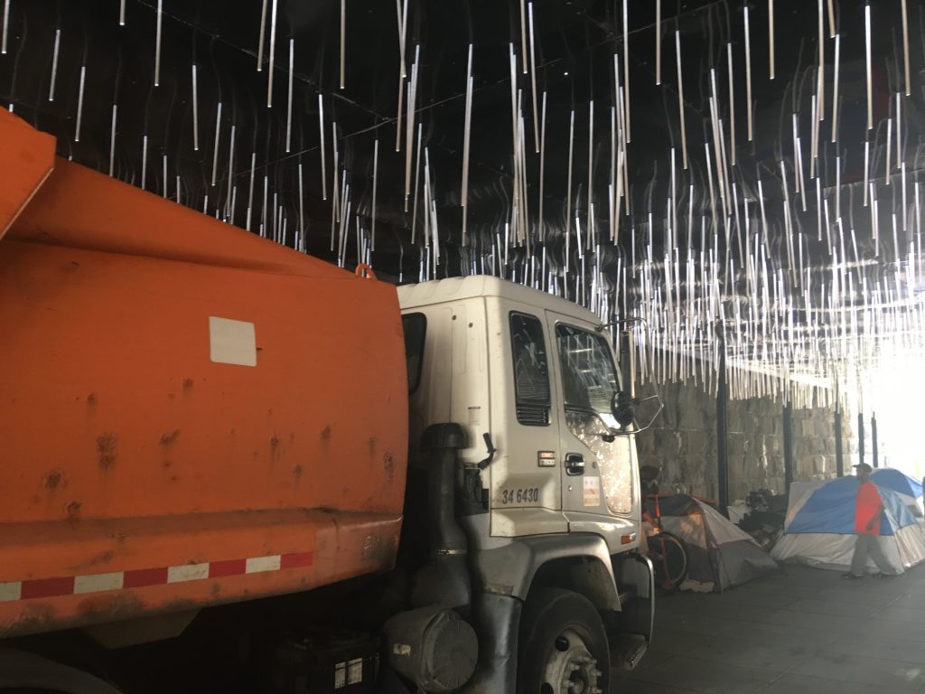 A photo of a garbage truck visiting an encampment site in NoMa.