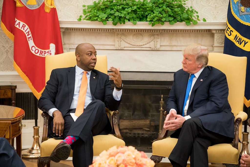 President Donald Trump sits with Senator Tim Scott, a republican from South Carolina, at the White House.