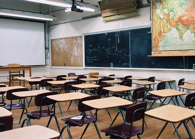 Image of an empty classroom with desks.